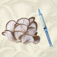 A flush of blue oyster mushrooms in front of a blue oyster liquid culture syringe.