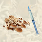 A flush of pioppino mushrooms beside a pioppino liquid culture syringe.